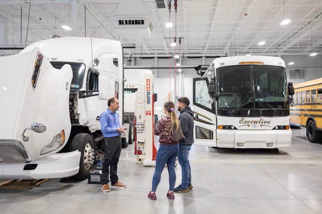 A family speaks with a faculty member in our Diesel Technology lab during Open House.