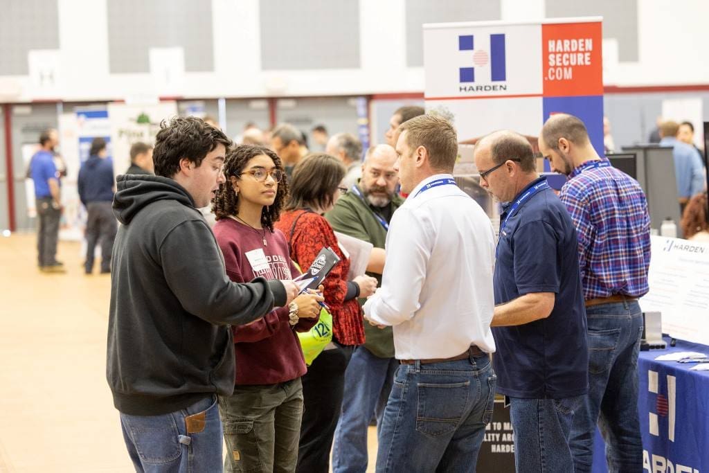 Students speaking with an employer at a career fair. 