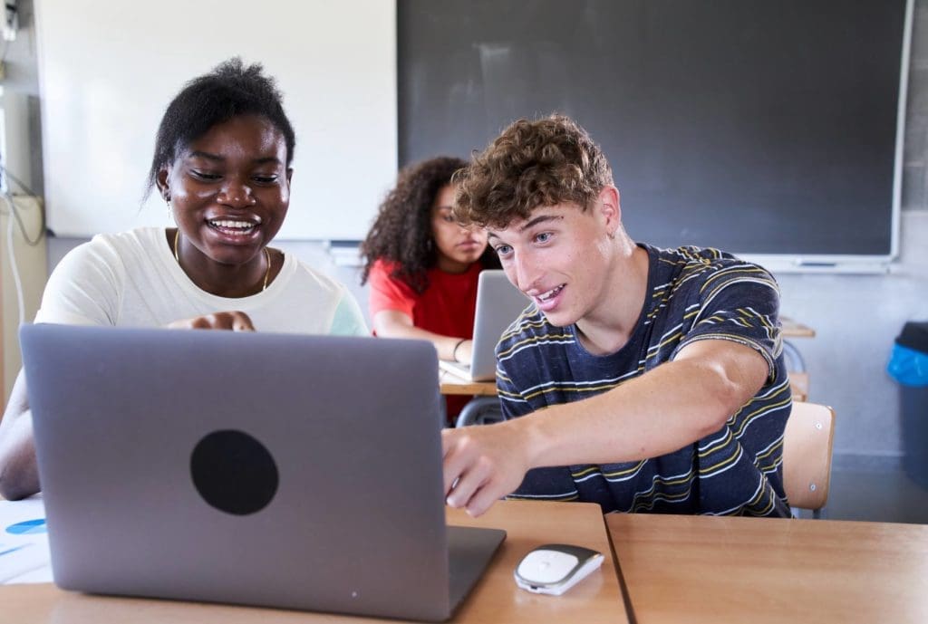 Students looking at a laptop together.