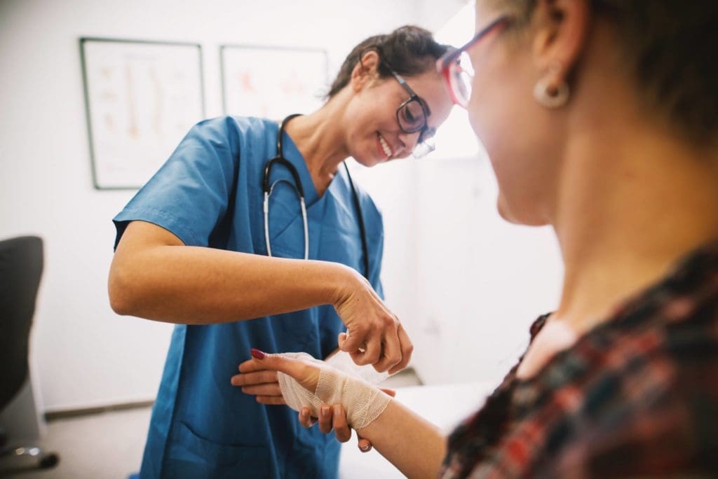 A nurse helping a student with a bandage. 