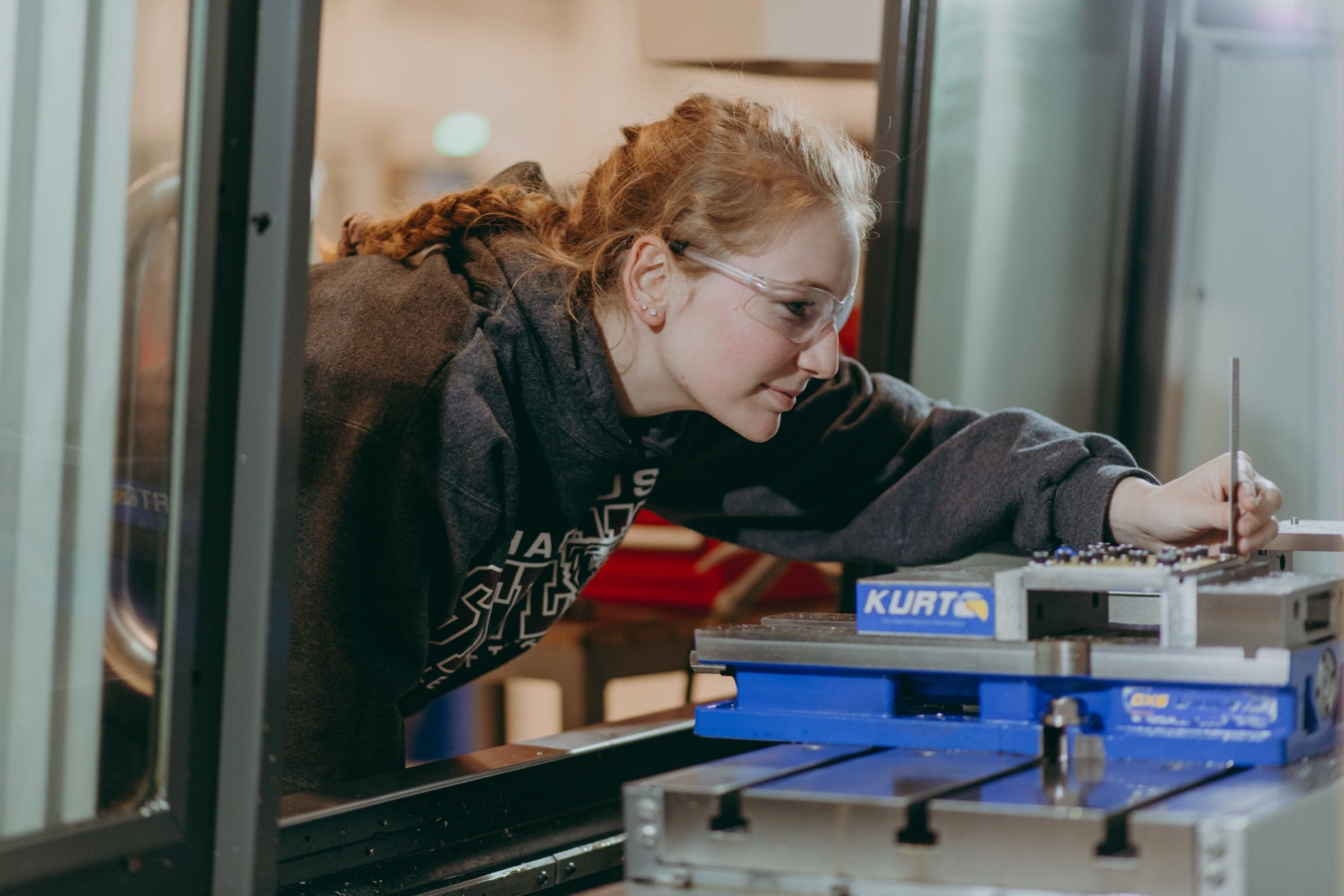 A student in the Computer Integrated Machining program examining settings. 