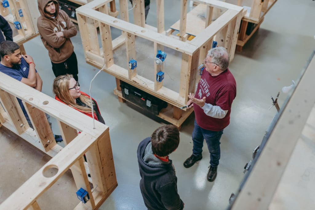 A faculty member teaches students in a commercial and industrial focused class. 