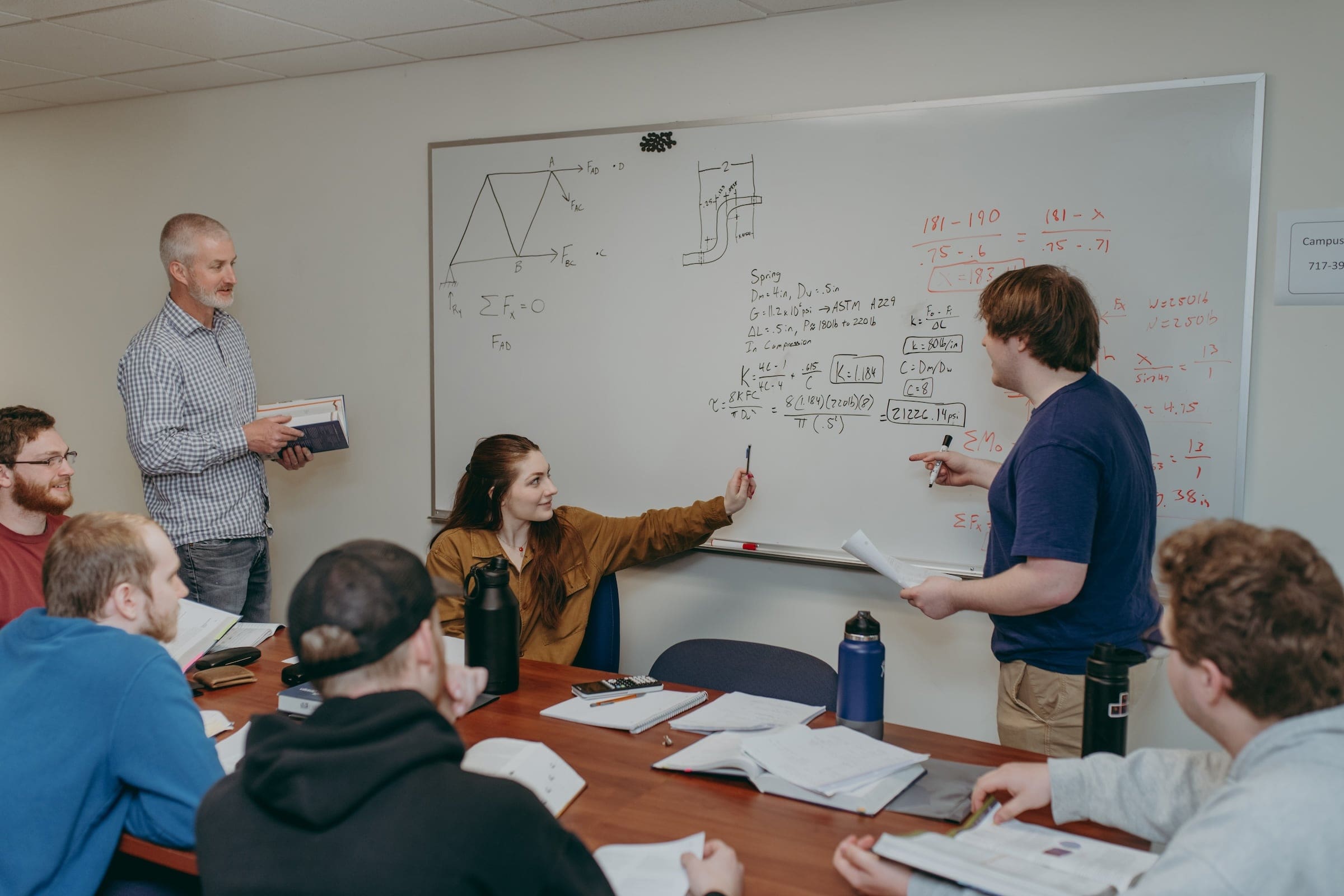 Students discussing a challenging problem in their mechanical engineering technology class.