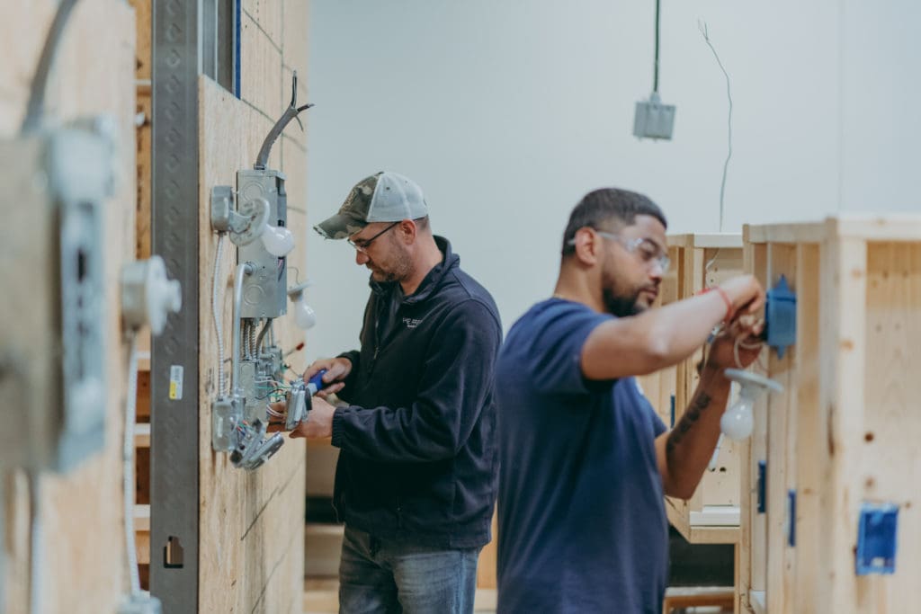 Two students learning facilities maintenance skills in the Facilities Maintenance Technicial program. 