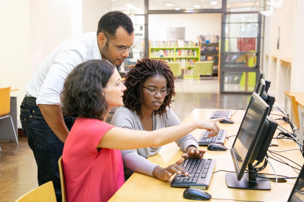 A professor helping students in IT class.