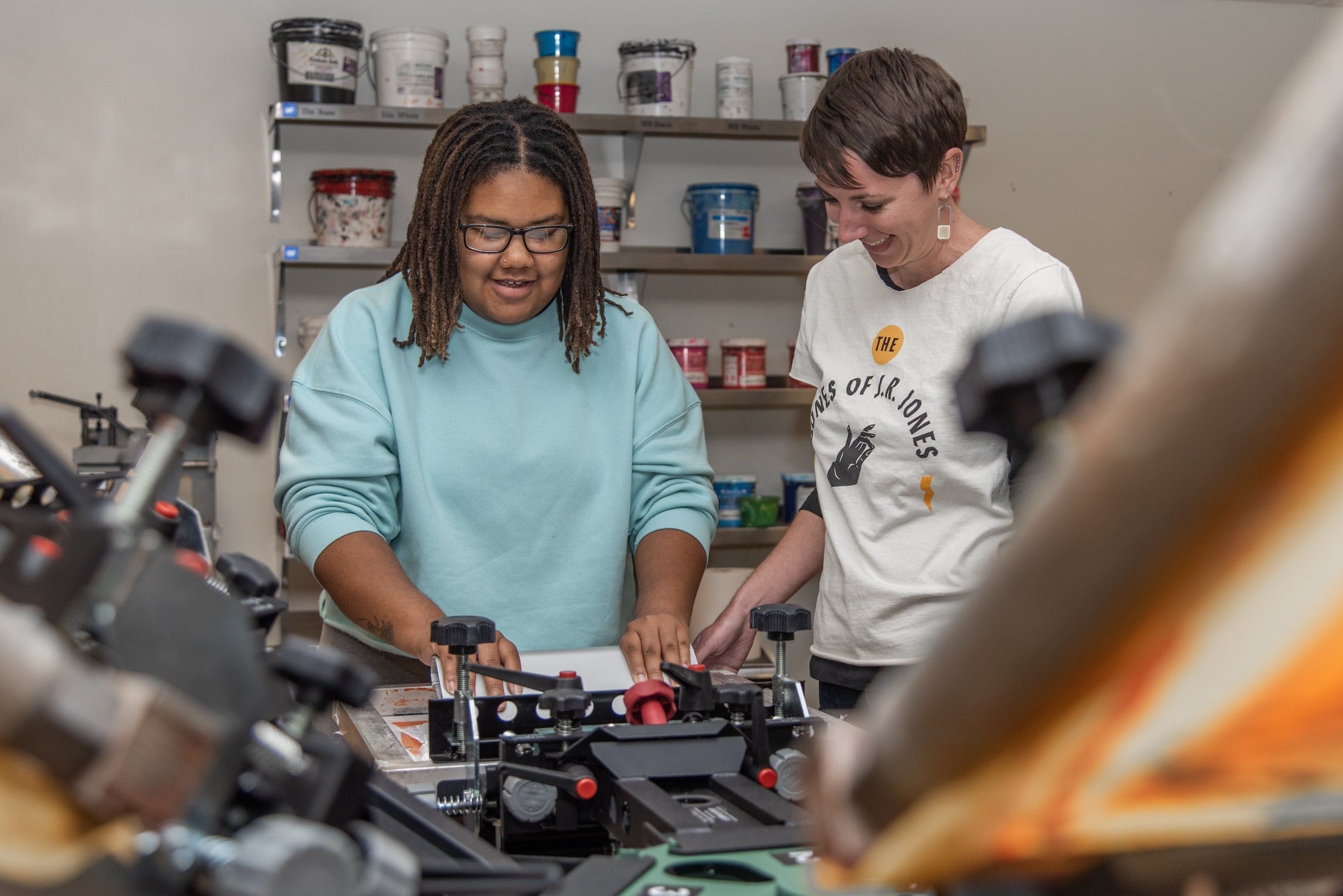 Graphic Communications and Printing Technology instructor practices screen printing with a student.