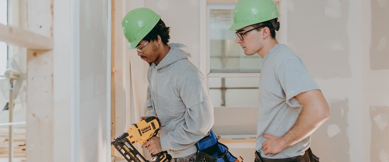 Two students work on a home remodeling project in the carpentry program. 