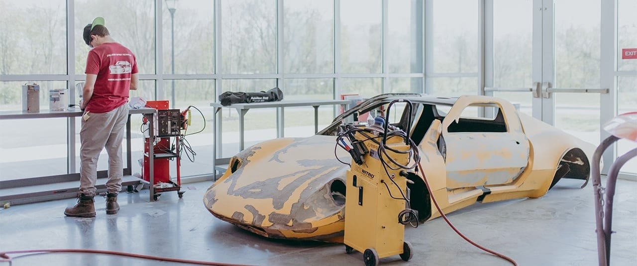 TSCT Collision Repair Technology student working on old sports car in the Transportation Center