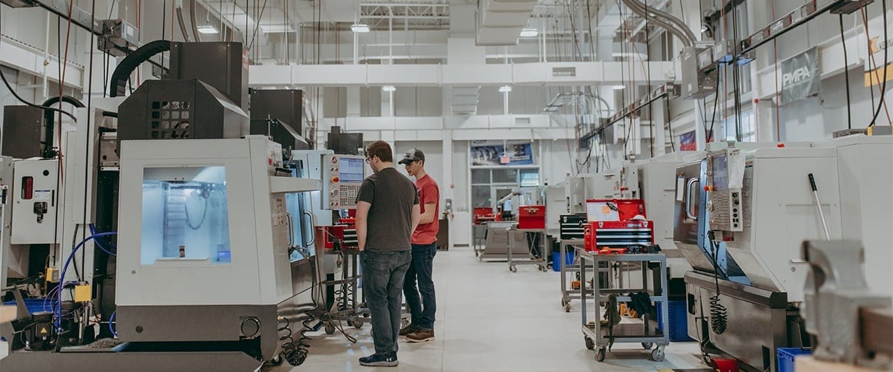 TSCT Computer Integrated Machining students standing by equipment in their Greiner Advanced Manufacturing Center lab