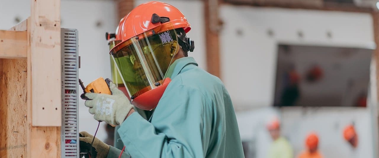 A student in the Electrical Technology program at Thaddeus Stevens College of Technology in safety gear testing an electrical box. 