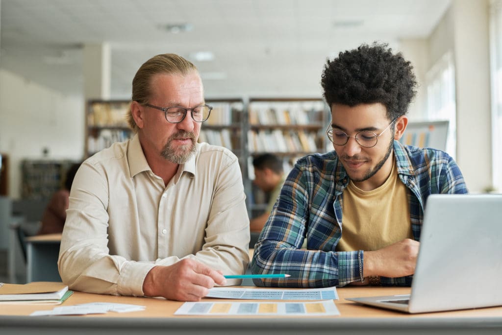 A student sits with a tutor. 