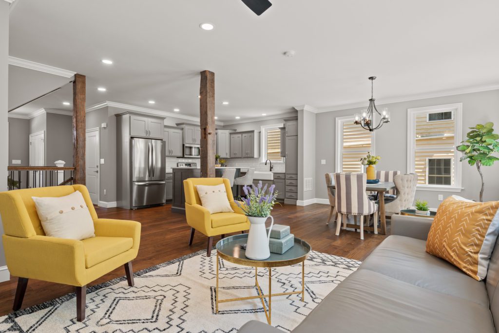 Home construction project interior living room staged 2022 yellow chairs and grey furniture and walls. 