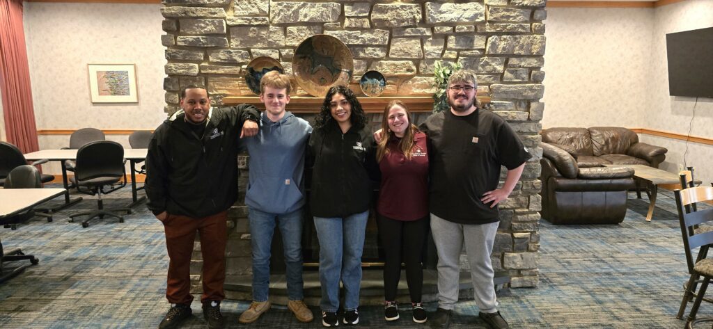 Five students in the common lounge area of Reighard Hall
